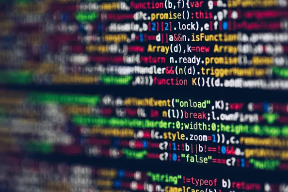 En suddig vy av datorkod som visar olika programmeringssyntax och färgade textsträngar.